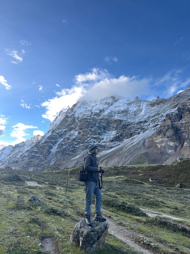 A man standing in front of the snowy mountains of Kanchajangga.