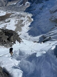 Lobuche Peak Climb A man going down a snowy mountain with ropes
